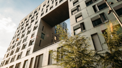 Close-up of the Diagonale building with a large rectangular cutout, windows, and trees in front.
