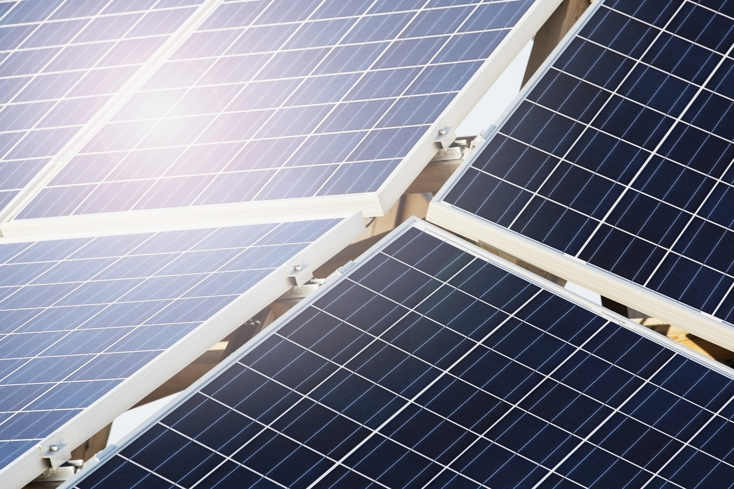 Close-up of solar panels arranged in a grid, reflecting sunlight.